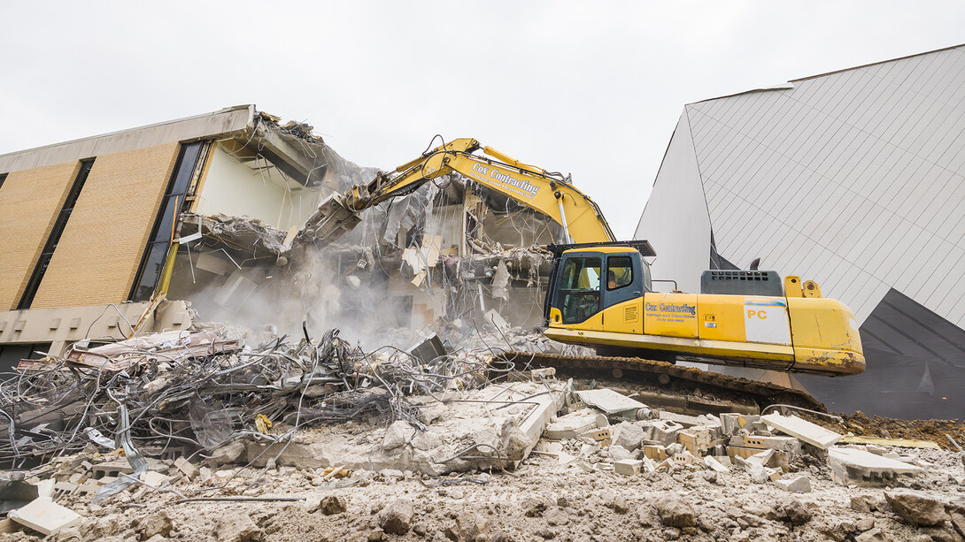 An excavator knocks down sections of the old Westbrook Music Building on July 24. The building is being removed as work is being completed on the new Westbrook Music building.