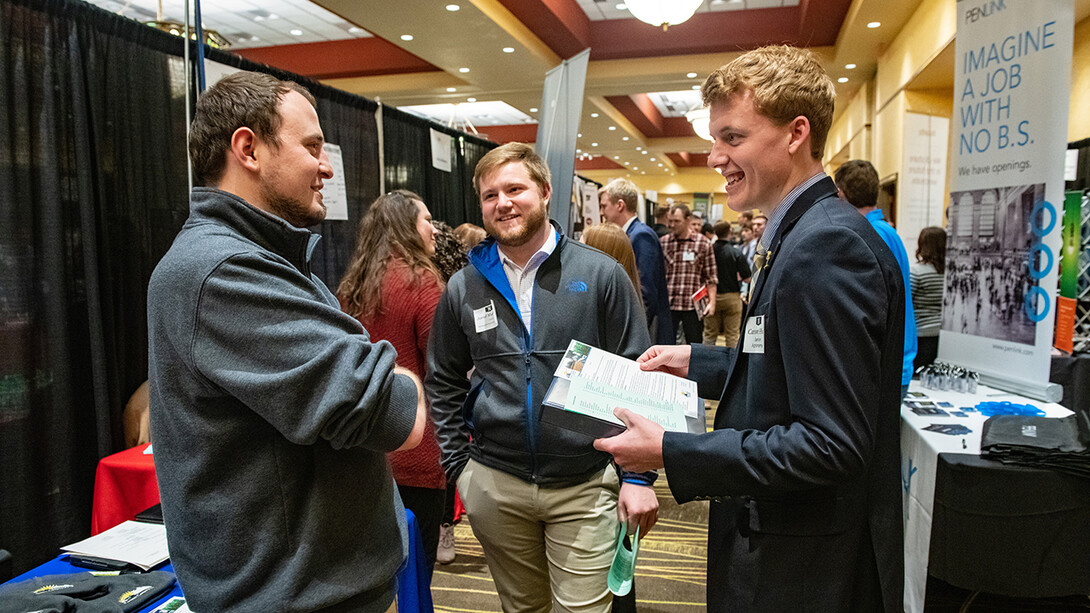 Jared Muhlbach and Carson Hicks talk with a recruiter from Farmers Cooperative at the STEM Career Fair in spring 2019.