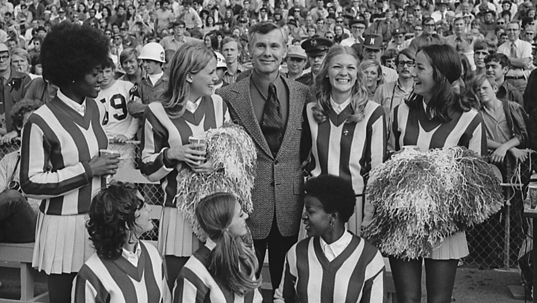 Late-night television icon Johnny Carson, a 1949 Husker graduate, poses with Nebraska cheerleaders in Memorial Stadium during the 1971 football game with Kansas.