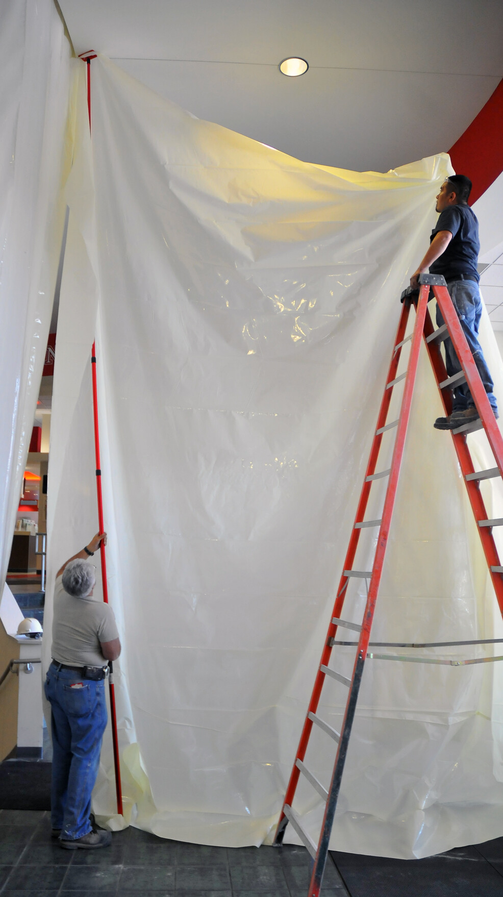 Midwest Demolition employees hang plastic sheeting before starting to remove ceramic tiles in the Nebraska Union.