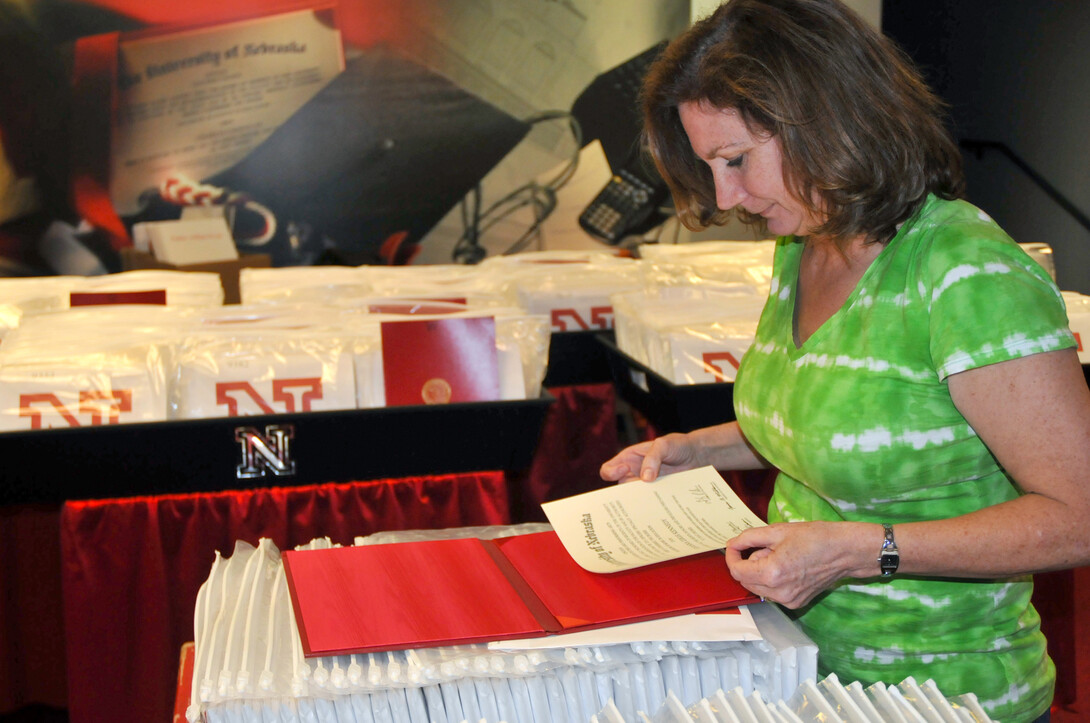 Patti Jones, a senior office associate in the Registrar office, puts together a diploma that will be handed out during UNL's May 4 commencement exercises in Memorial Stadium.