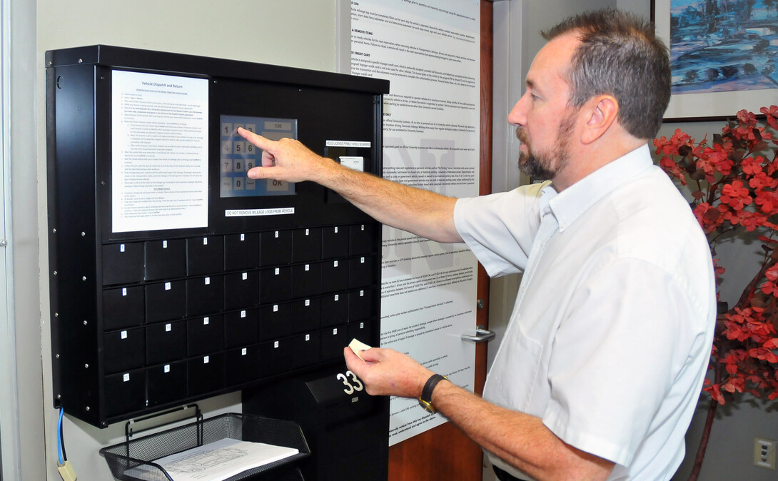 Patrick Barrett, director of transportation services, demonstrates the new automated auto rental system available on City and East campuses. Barrett was honored by the National Association of College and University Business Officers for the implementation of the Keyosk system. 