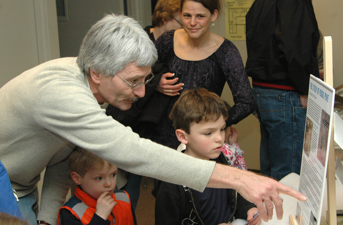 Rob Skolnick, a preparator with the University of Nebraska State Museum, explains the history of fossil puke to two children during the 2011 Dinosaurs and Disasters event in Morrill Hall.