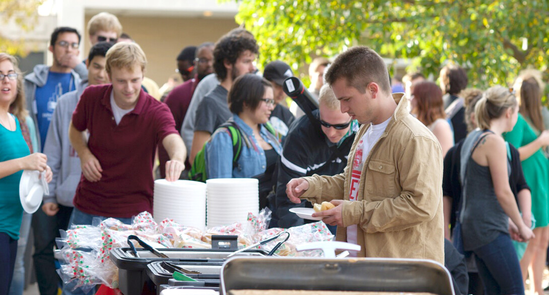 Students in UNL's fine and performing arts and architecture colleges stand in line for free food during the Oct. 24 tailgate outside Kimball Hall. The event was held as part of the proposed consolidation of the two colleges.