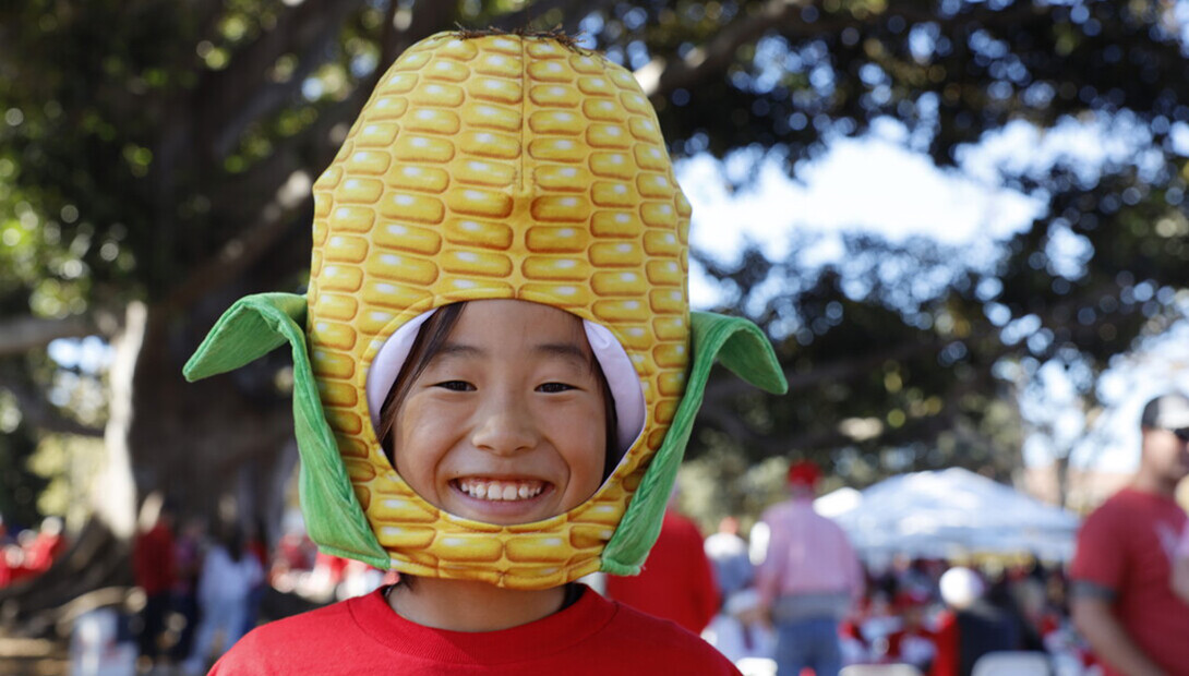 A Husker fan is wearing a corn cob hat