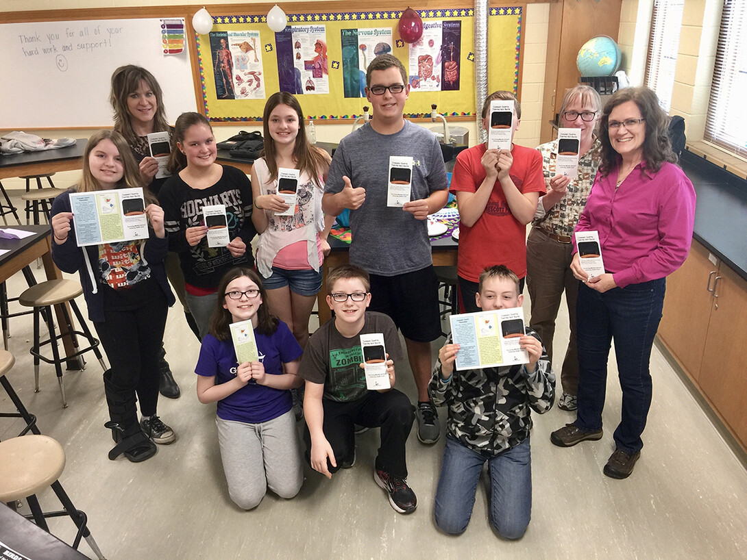 Mary Bomberger Brown poses with students from Irving Middle School. She supported an after-school program at Irving and worked with students who successfully saved a swift roosting spot within a chimney at the school.