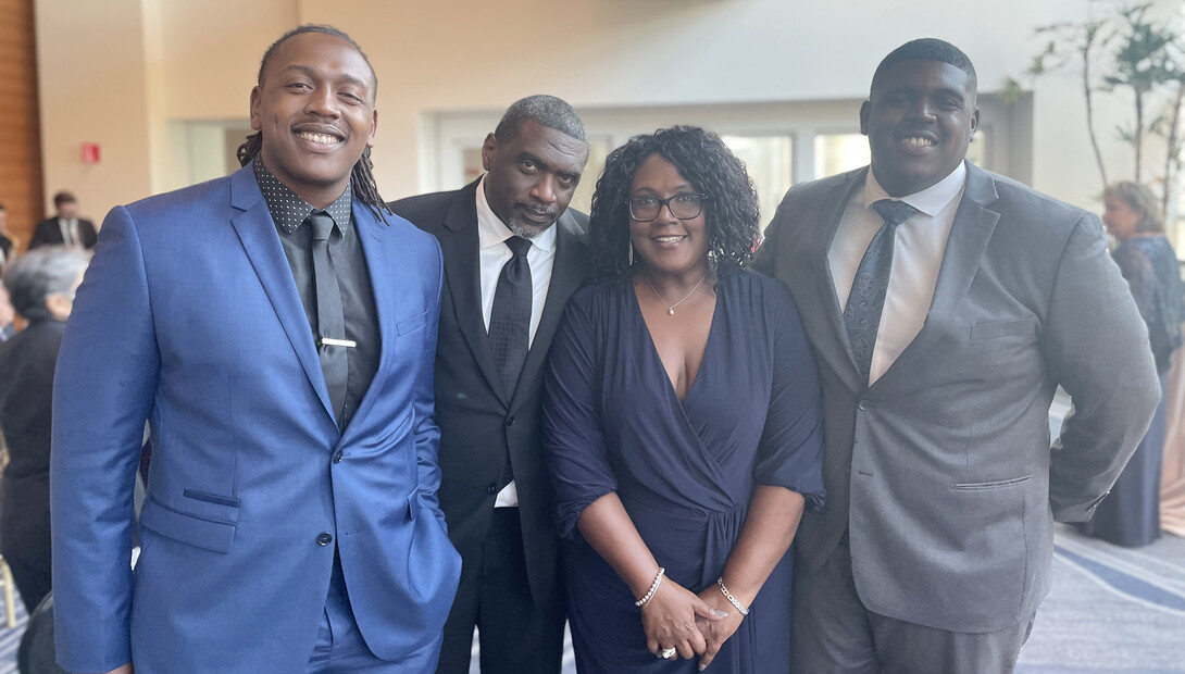 Charlie Foster poses for a photo with her husband and two sons.