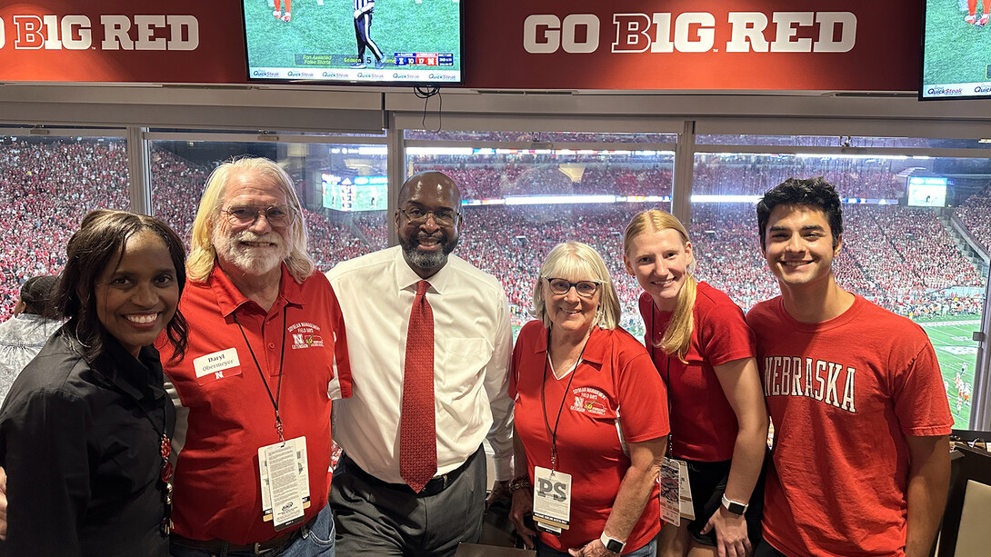 Daryl Obermeyer (second from left), a farmer from Brownville, stands with (from left) Temple Bennett, Chancellor Rodney D. Bennett, and Obermeyer's guests in a Memorial Stadium suite on Sept. 20. Obermeyer was selected to be a Chancellor's Champion and attended the game with Illinois.