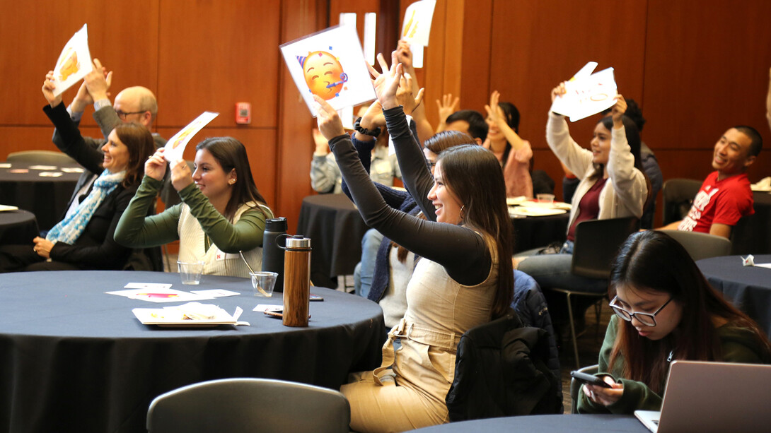 Audience members hold up emojis in response to a Slam talk on March 31.