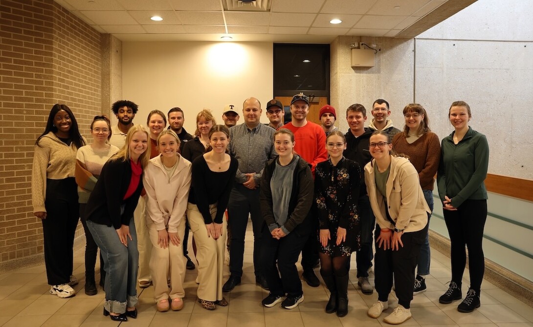 A group of people poses in a hallway.