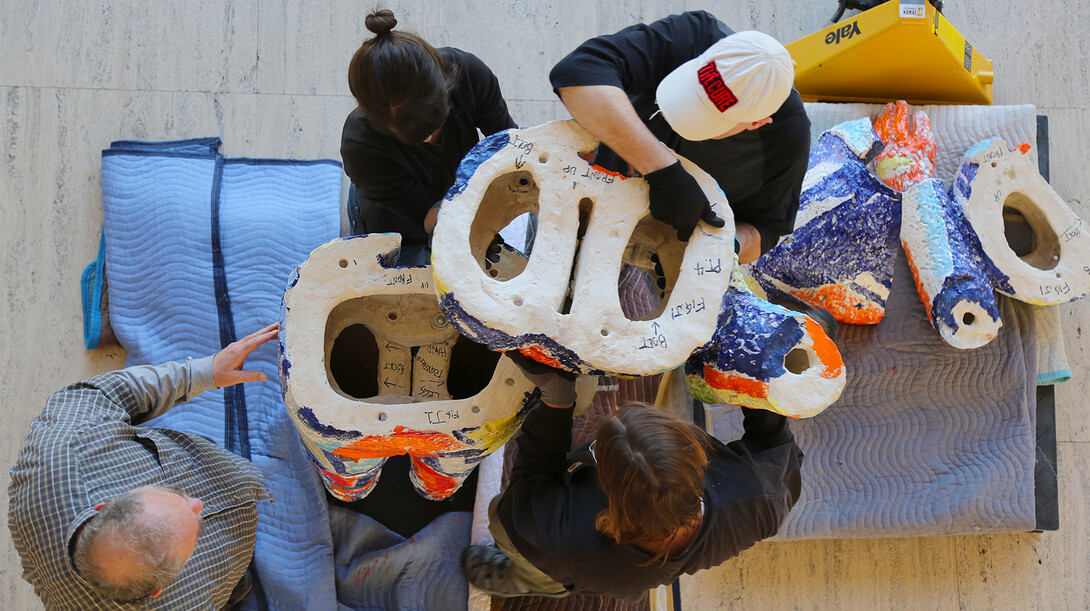 Preparators at UNL's Sheldon Museum of Art move a piece of "Handout Man" into place during an install on March 30. The larger-than-life sculpture is on display in the Sheldon's Great Hall.