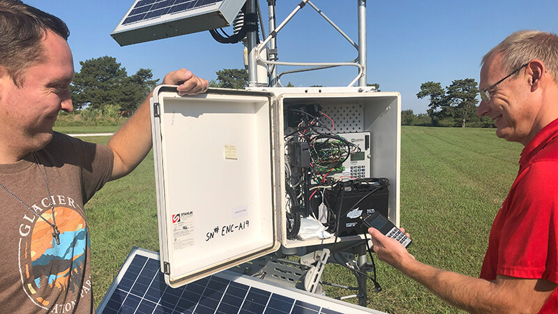 Derek Johnson (on left), a Nebraska Mesonet field technician, and Ruben Behnke, the Nebraska Mesonet manager, check readings at an East Campus weather station.