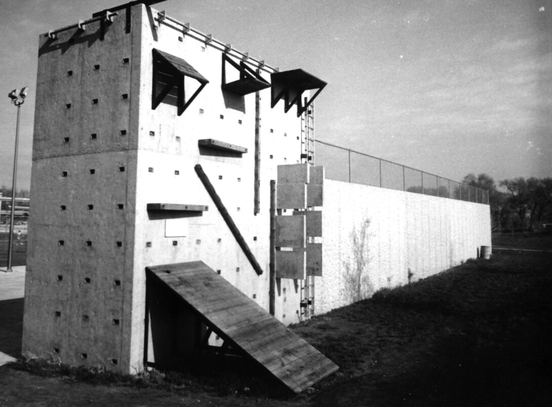 UNL's first climbing wall was built in 1976. The wall allowed for various climbing elements to be bolted onto it. The wall also served as a backstop to East Campus tennis courts.