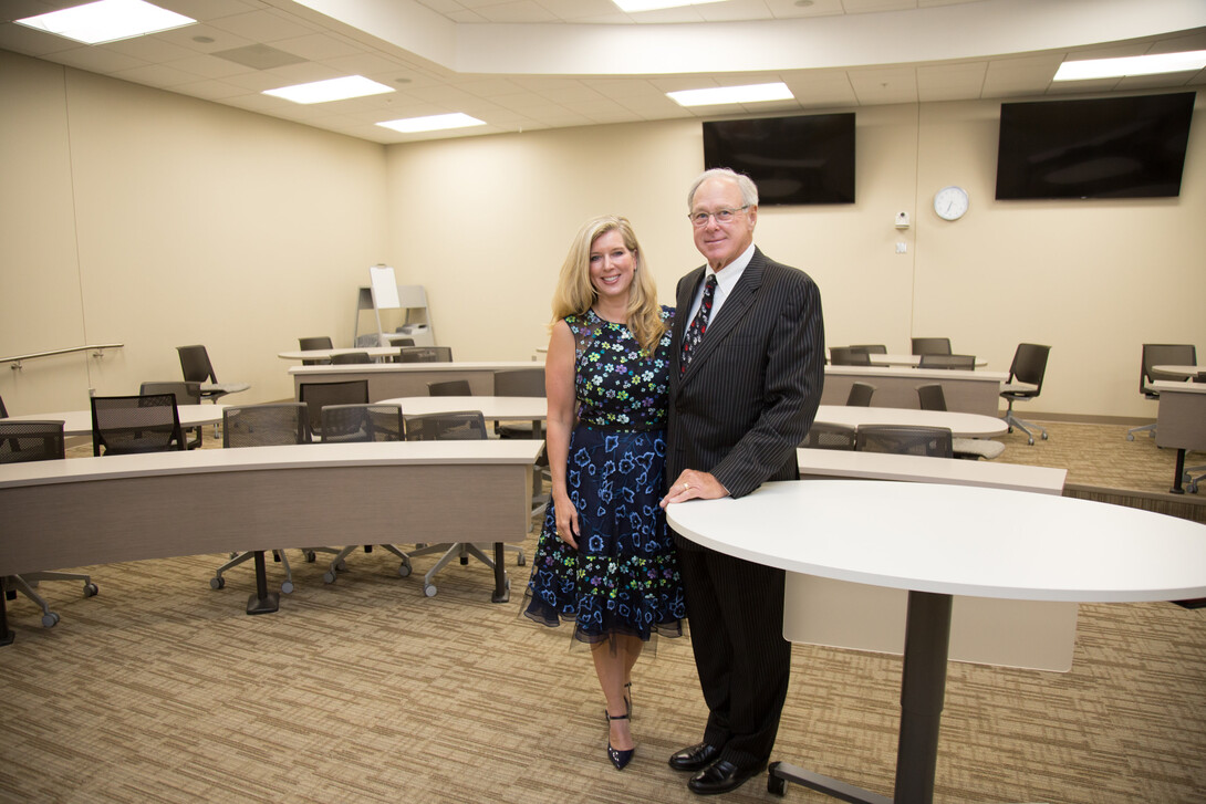 Lisa and Tom Smith, pictured in the Howard L. Hawks Hall classroom they funded, will establish a presidential chair in finance in the College of Business. A presidential chair is among the university’s most prestigious faculty awards and will help to attract and retain top faculty.