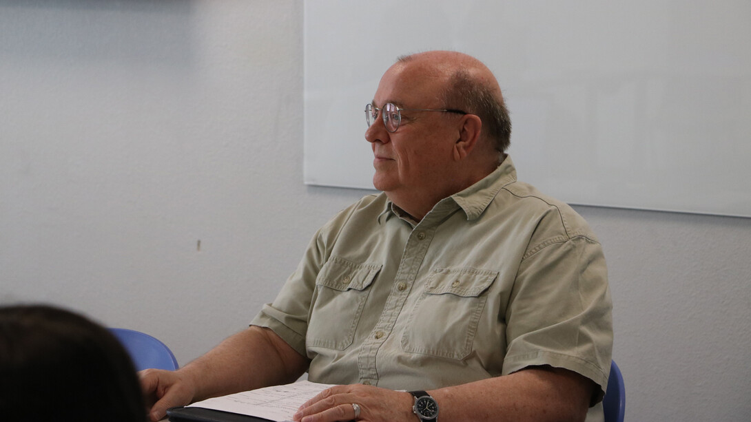Donald Beahm, a white man with a round bald head and glasses, sits in a cream shirt.
