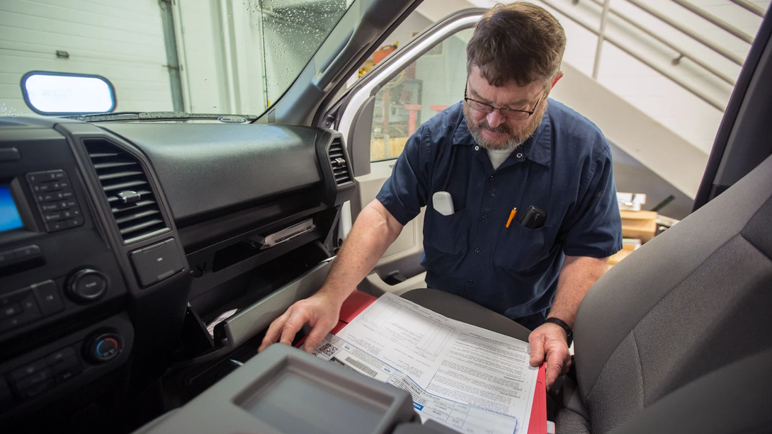 Warren Nettleton examines paperwork for a new pickup truck in the fleet management garage.
