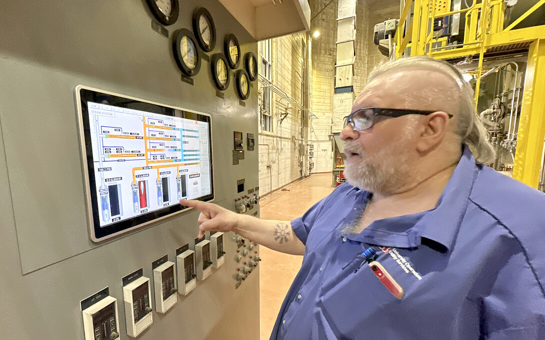 Kenneth Smith explains information displayed on a screen that is part of a chiller within the City Campus utility plant.