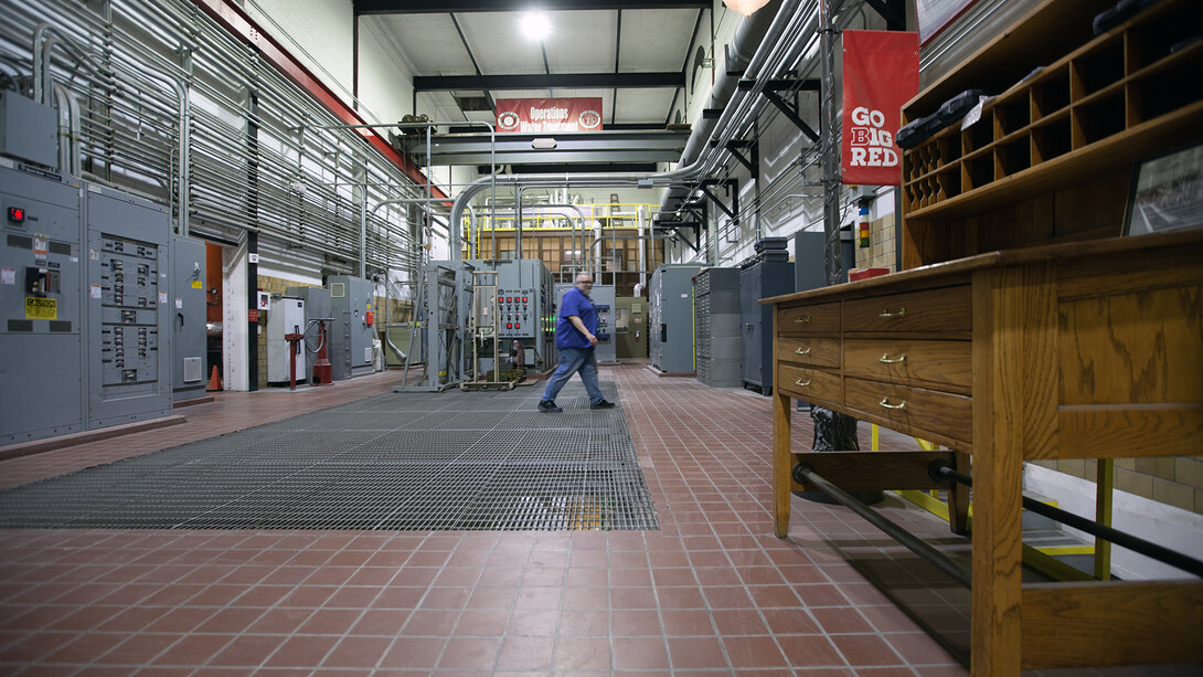 Kenneth Smith crosses from the boiler room toward the chiller room in the university's City Campus utility plant.