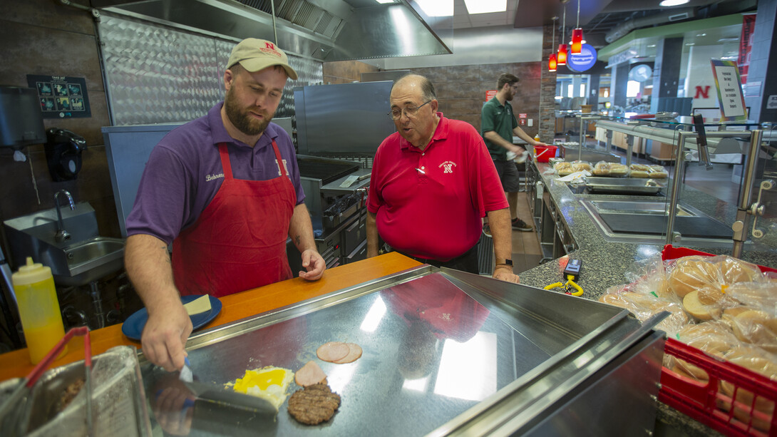 Nebraska's Harry Tilley (second from left) talks with Behrendt Rippe, a senior dining service associate, in the Abel-Sandoz Dining Center. Tilley retired Aug. 3 after 53 years of service in University Housing dining centers.