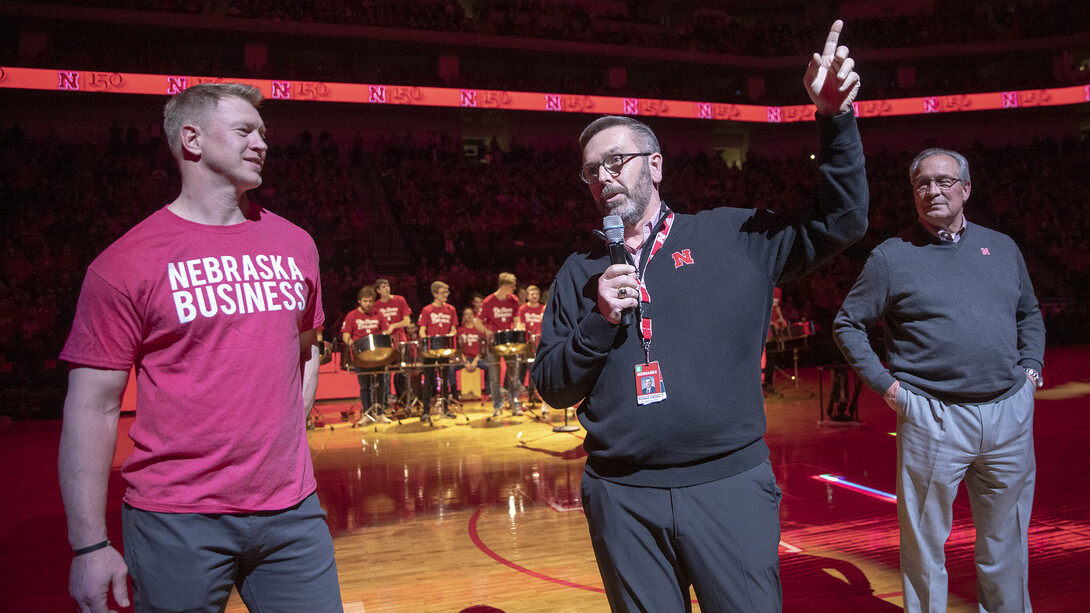 Chancellor Ronnie Green talks to Husker fans at halftime as Scott Frost (left) and Bill Moos look on.