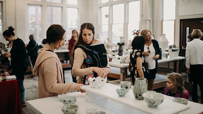 Patrons peruse pottery options during a Clay Club Sale in Richards Hall.