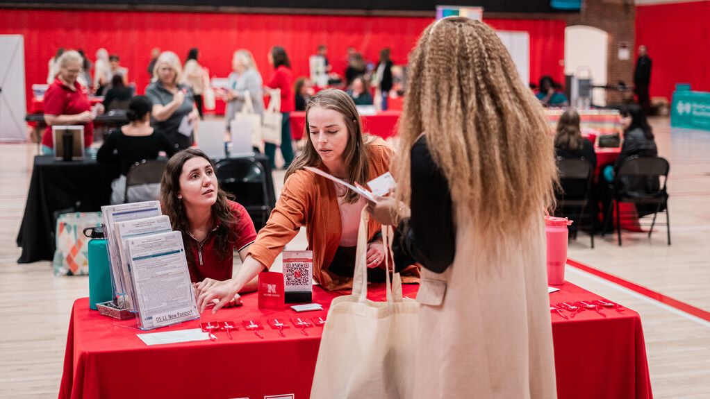 Employee talking with representatives at a wellness fair.