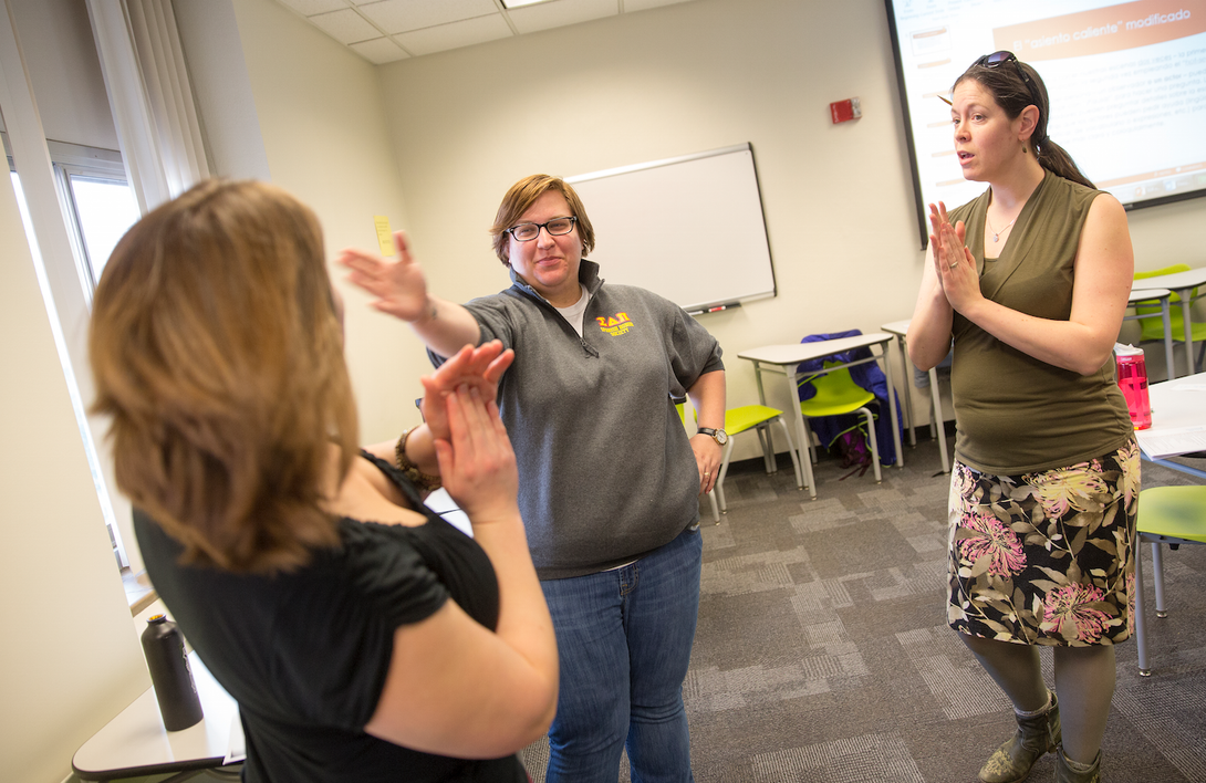 Kelly Kingsbury Brunetto watches as Jocelyn Swanson and Eleanor Dynek practice "stage combat". Spanish class where students do improv and one-act plays to help with their speaking skills.
