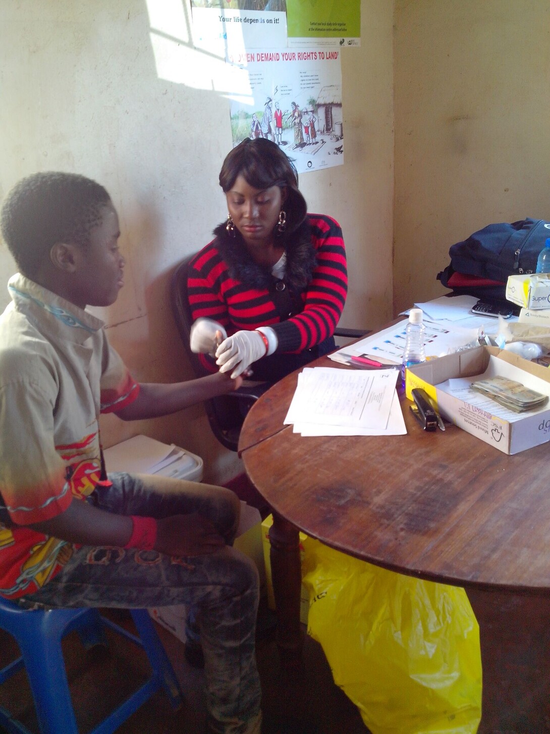A social worker takes a sample of blood to test for HIV during a data collection in Lusaka, Zambia, in 2014.